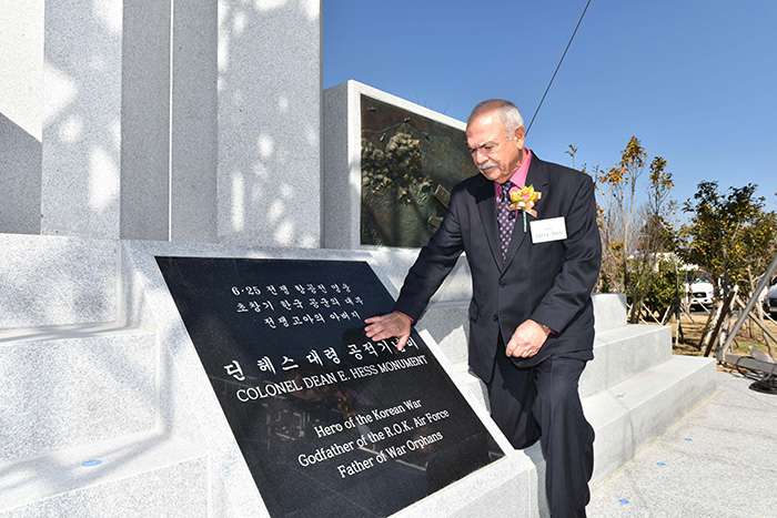 In this photo taken on March 9, 2017, and provided by the Air Force, Larry Hess, the eldest son of the late Col. Dean E. Hess, touches on the monument built to remember his father's contributions during the Korean War.
